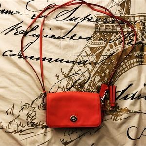 Red orange Coach mini crossbody bag.
